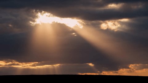 Beautiful sun beams on a dramatic sky full of clouds - time lapse shot