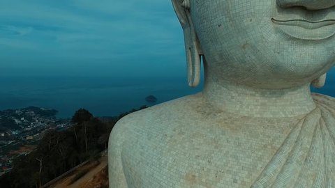 Aerial: Flying near Big Buddha's face.