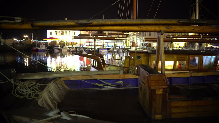 Panorama of wooden fishing boat parked in harbor, beautiful evening cityscape