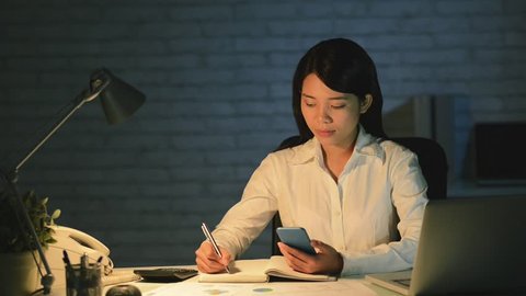 Cinemagraph of Vietnamese business lady writing ideas in notepad  Adlı Stok Video