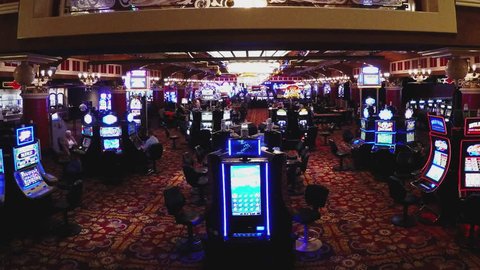 LAUGHLIN, NV/USA: November 21, 2016- Wide shot of a slot machine gaming area in a gambling casino. Empty slot machines stand at attention with inviting lights awaiting patron's money.