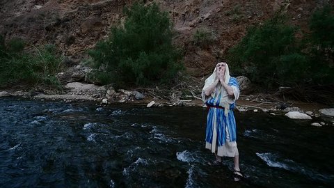 Jewish Man is Bathing in a River Sprays the Water, Washes His Face, Raising Hands Up. Man Sits and Leans Down and Picks up the Water, Sprays it Around, Slow Motion. Ablution in Judaism. Man in