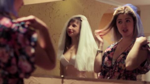 Girls in bathing suits and a veil dancing on the eve of the wedding bachelorette party