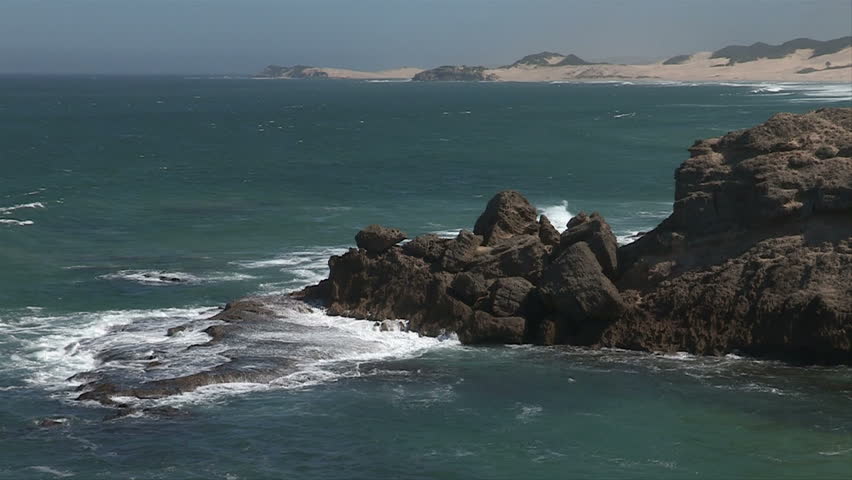 Slow motion of waves crashing against rocky coastline