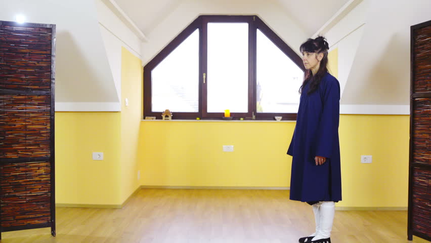 Teacher and student of martial arts greet with bow 4K. Wide shot of two person in focus greet each other with traditional bowing inside gym. Bright window in background.
