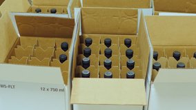 Packaging bottle with alcohol. Work puts bottle of wine in cardboard boxes - Powered by Shutterstock - Get 15% off with code: PIKWIZARD15