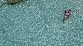 aerial video of a couple hugging in tropical water, The Baths, Virgin Gorda, British Virgin Islands 