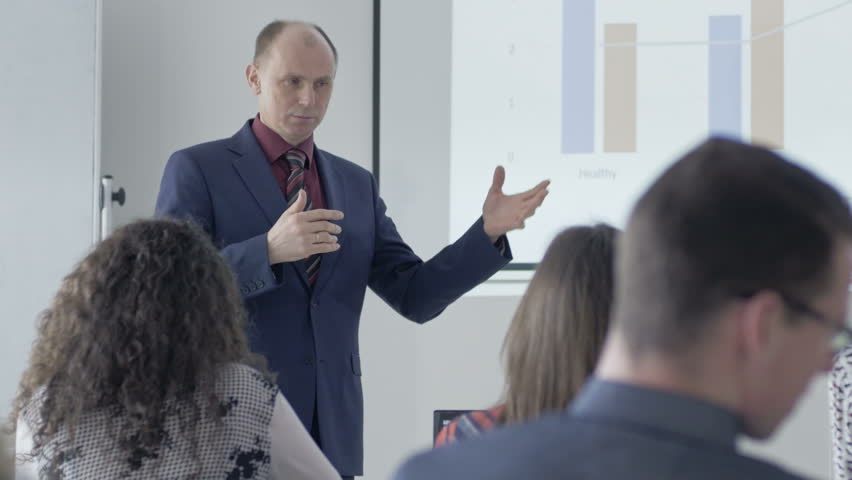Experienced lecturer speaking in front of the classroom. Professor holding a seminar for a group of students. | Shutterstock HD Video #21687379
