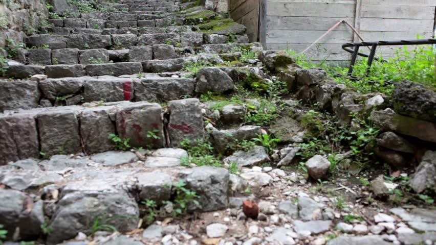 Female and children legs rising up on stone stairs of old fortress of Kotor. Montenegro