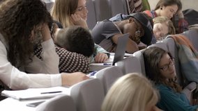 A lot of tired young people sleeping in the lecture hall during a boring presentation. Unmotivated young students feeling exhausted in the auditorium during a presentation. - Powered by Shutterstock - Get 15% off with code: PIKWIZARD15