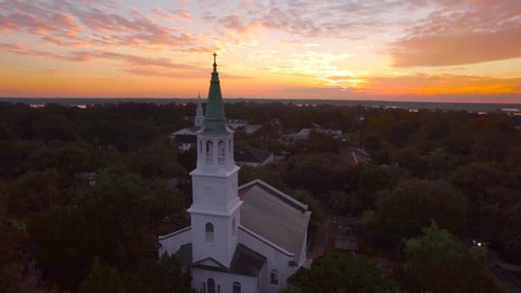 4k Aerial stock footage of historic cathedral, church at bright orange sunrise in Beaufort South Carolina
