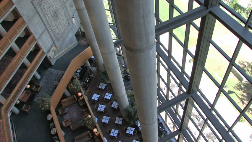 Balconies and resort lobby looking down above. Large columns, restaurant tables and expansive glass windows open to the mountains. Salt Lake City, Utah. Scenic and luxury hotel, timeshare and resort.