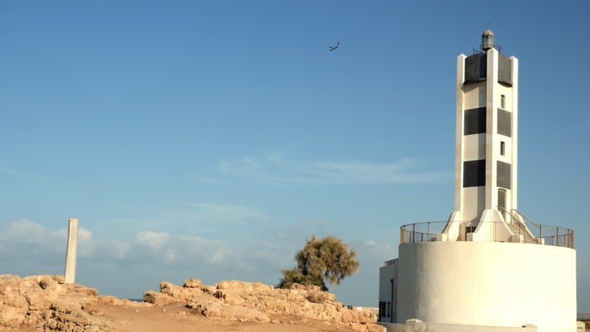 aircraft landing behind light house