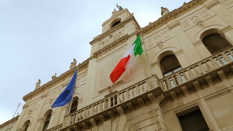 Italian and European flags on the historic building of Town Hall of Padua. Palazzo Moroni, Comune di Padova, shooting from the bottom of. Palazzo Moroni - seat of the Municipality of Padua, Italy