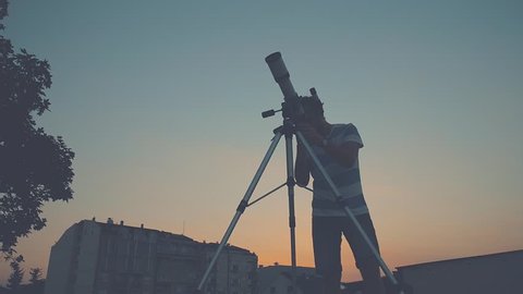Man looking through a telescope.