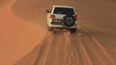 ABU DHABI, UAE - AUGUST 20, 2014: Desert Safari SUVs bashing through the arabian sand dunes. View from the car 13.