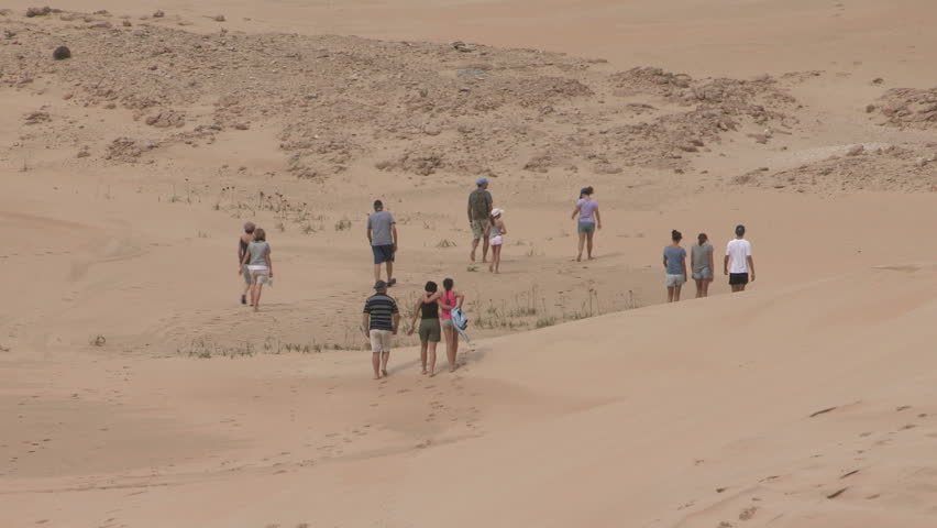 Family walking on sand dune desert