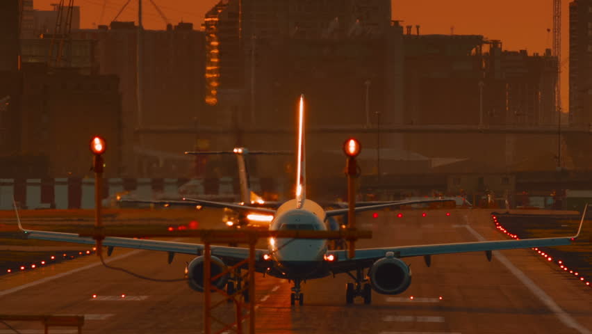 London City Airport - An ultra closeup of an airliner preparing to take off during sunset time. It opened in 1987 and serves the twin centers of London financial industry: City and Canary Wharf Royalty-Free Stock Footage #21711382