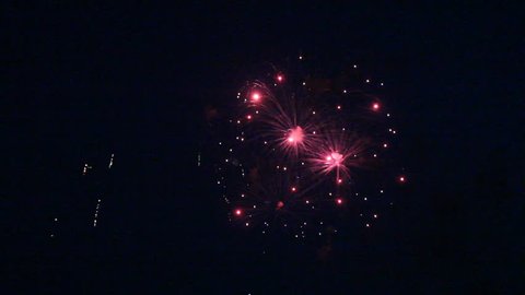 Multiple bursts of fireworks during a night time celebration for the Fourth of July