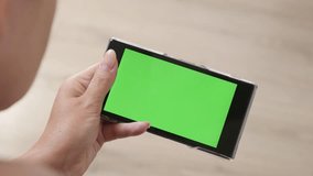 Female on floor holds green screen display tablet 4K 2160p 30fps UltraHD footage - Close-up of woman at home with greenscreen smart phone 3840X2160 UHD video