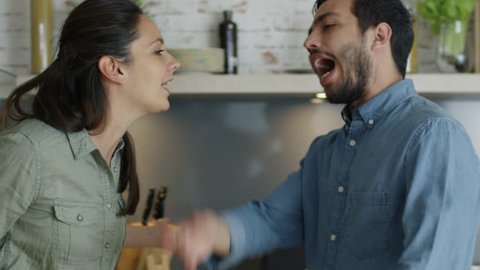 Young Couple Quarrels in the Kitchen. Man and Woman Scream in Frustration and Angrily Gesticulate. Shot on RED Cinema Camera in 4K (UHD).