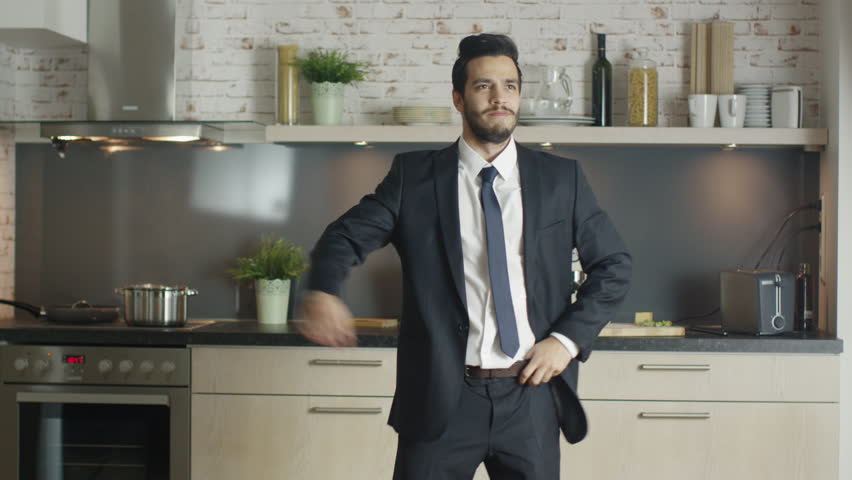 Classy and Handsome Young Businessman Dances Energetically at His Kitchen. Shot on RED Cinema Camera in 4K (UHD). Royalty-Free Stock Footage #21728545