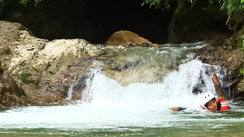 Group of two young people swimming and jumping into an Ecuadorian rainforest