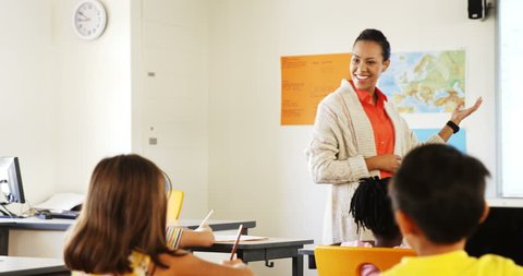 Side view of mixed race teacher teaching in classroom at school