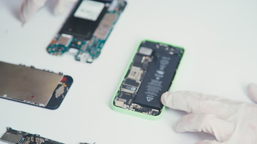 Close-up of a cell phone repair. The internal components of a smartphone. Disassembled cell phone. Cell Phone Battery. Master disassembled mobile device for detail. Chips and details of the smartphone Royalty-Free Stock Footage #21737935