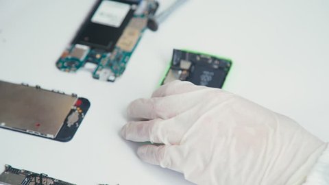 Close-up of a cell phone repair. The internal components of a smartphone. Disassembled cell phone. Cell Phone Battery. Master disassembled mobile device for detail. Chips and details of the smartphone