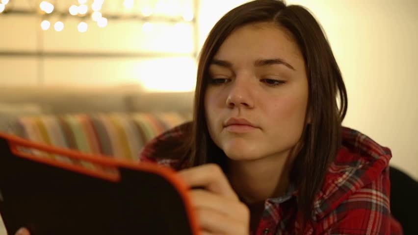 Young woman with pen and notebook writing in bed at home bedroom
