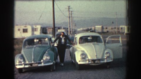 RHODES GREECE 1962: man poses with two vw beetles
