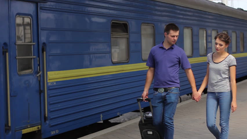 Very beautiful couple walking holding hands on the station platform