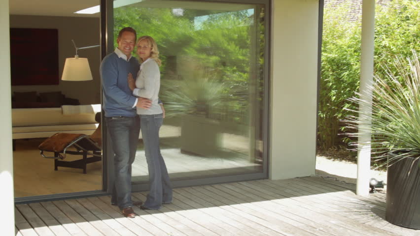 Wide, Track shot portrait couple standing in front of house