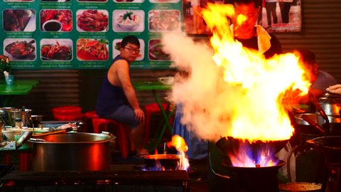 BANGKOK - NOV 18: A chef cooks food at a street-side restaurant in Chinatown on November 18, 2016 in Bangkok, Thailand.