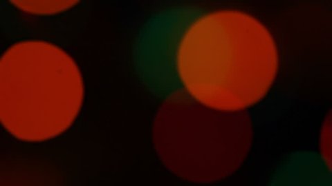 Defocused blinking Christmas lights on dark background
