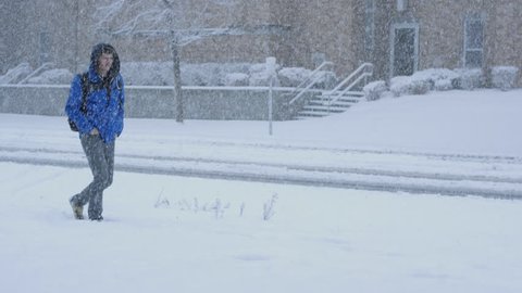 Boy walking in a snow storm.