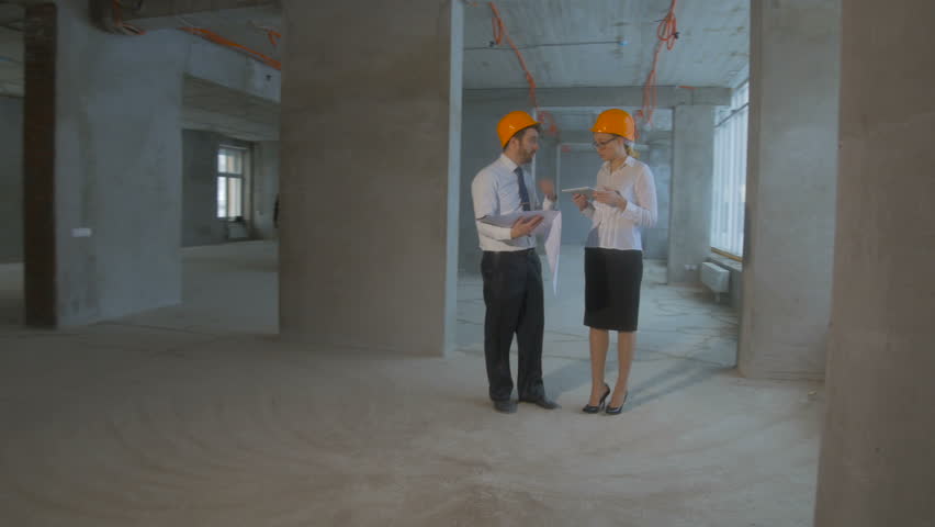 Businessman and business woman in suit, hard hat communicate, discuss blueprint, construction site. | Shutterstock HD Video #21792136