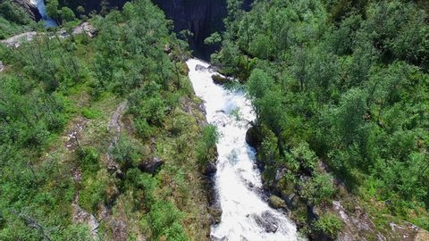 Flight above small river which turns into massive tall waterfall Voringfossen waterfall in Norway, popular major tourist attraction.