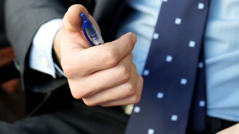 Businessman holding a pen and playing with it, steadycam shot
