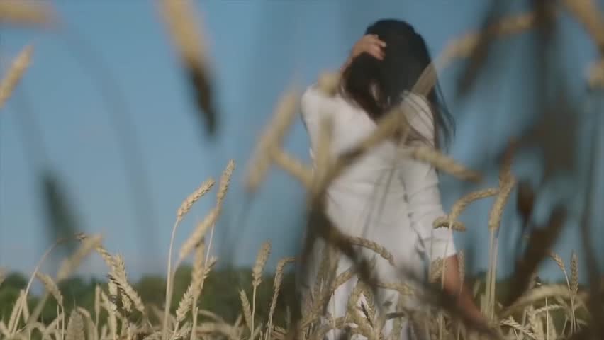 B eautiful romantic young woman in the field of wheat ears