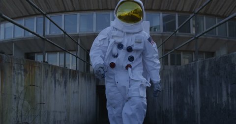 4K Funny astronaut doing a dance as he walks away from mission control building. (UK-Oct 2016)