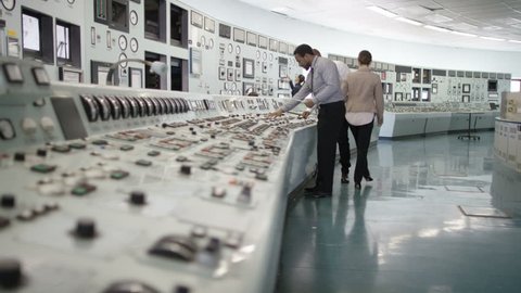 4K Workers in power plant control room, pressing switches on control panel (UK-Oct 2016)