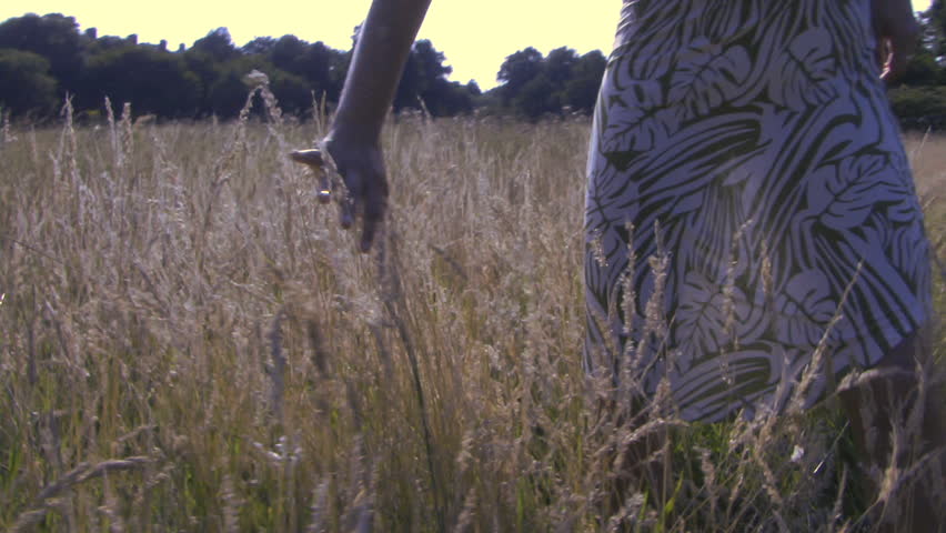 MEDIUM SHOT OF A WOMAN TOUCHING GRASS