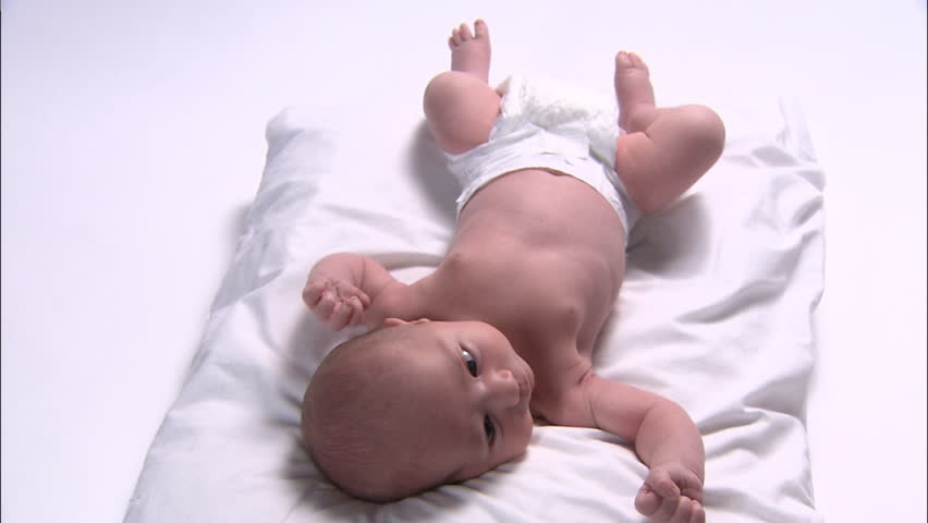 Front view of newborn baby's body lying down on pillow