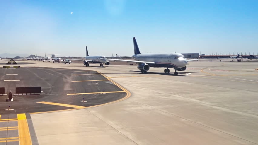Airplanes line-up on a runway waiting to take off.
