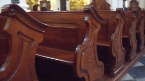 Old carved wooden benches in catholic church 4K steadicam video