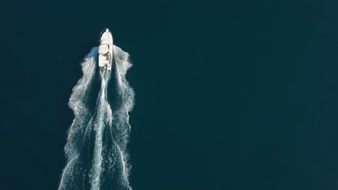 Aerial - Top down view of luxury speed boat cruising on water