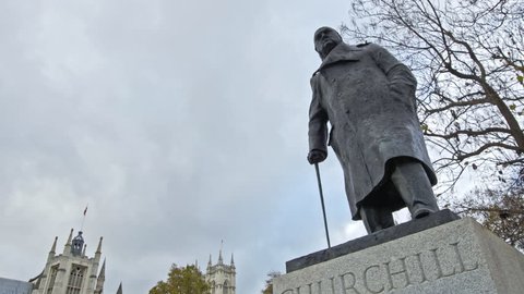 a panned walking shot of Winston Churchill in parliament square, London, England, united kingdom