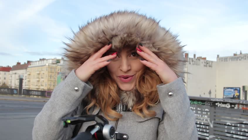 young beautiful girl in winter jacket with fur hood outdoor